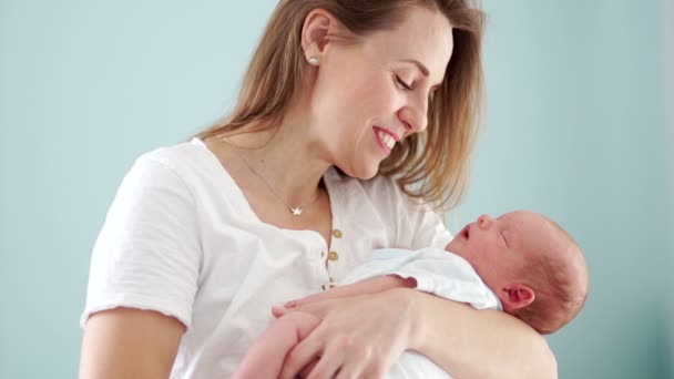 Anne kucağında yeni doğmuş bir bebek tutar. Kadın gülümsüyor, yavaşça onu okşadı. Annelik mutluluğunu. Anneler günü — Stok video