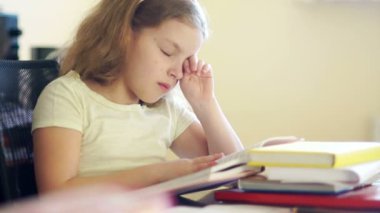 Bir yığın kitap masada oturan üzgün kız. O gözleri losyonları ve uyumak istiyor. Okul eğitim sorunları. Okula dönüş