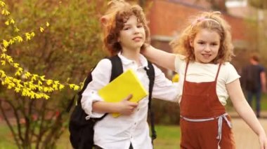 Kardeşim ve kız kardeşi, erkek ve kız bir çiçek açması ağaç bahar arka planı sarıl. Bilgi günü. Okula dönüş. Okul dostluk