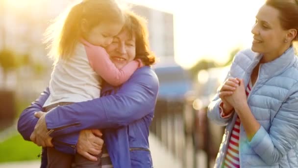 A mature woman, her adult daughter and little granddaughter. Joyful meeting and hugs. Mothers Day — Stock Video