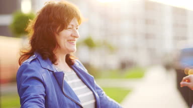 Toplantı kadın ve yetişkin kızı emekli oldu. Neşeli sarılmalar. Güneş doğuyor. Anneler günü