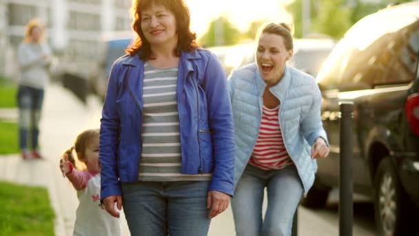 Drie generaties van vrouwen in de familie. Grootmoeder, dochter en kleindochter omhelzen en kussen elkaar. Mothers Day. Familie wandeling in de gemeente-werf. Zonsondergang — Stockvideo