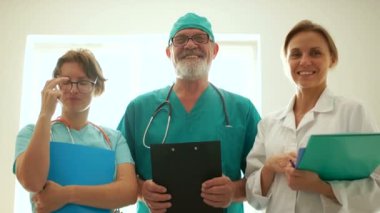 Kliniğin baş doktoru ve iki genç doktor stajyer. Tıp kariyeri, tıbbi geçmişi. Üç doktor yakından gülümsüyor.