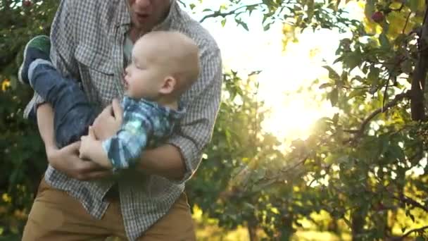 Far och son barn njuter utomhus. En lycklig familj, far och son, ha kul i trädgården vid solnedgången. Fadersdag — Stockvideo