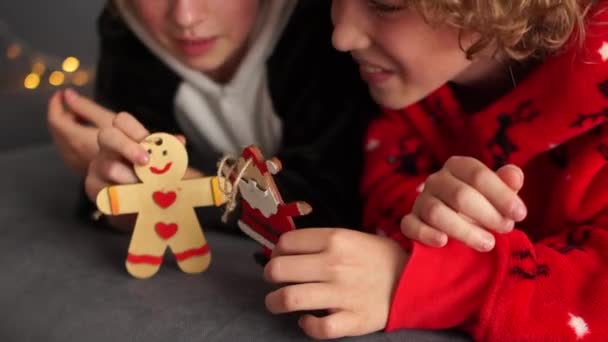 Kudrnatý bratr a sestra v vánoční pyžamo hrát s figurkami zdobí vánoční stromek. Rodinná dovolená Vánoce, vánoční dovolená — Stock video