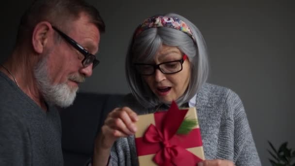 Anciana hermosa mujer recibió un regalo de Navidad de su marido y es muy sorprendido — Vídeos de Stock