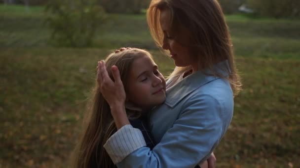 Chica colegiala abraza a su hermosa madre para dar un paseo en el parque de otoño. Día de las Madres — Vídeos de Stock