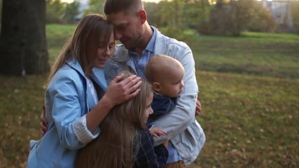 Familie mit zwei Kindern im Herbstpark. Mutter, Vater und Kinder. die älteste Tochter und der jüngste Sohn. Familienurlaub — Stockvideo