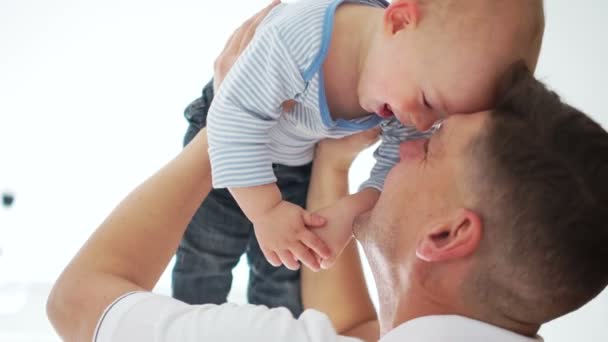 Pai feliz levanta seu filho criança sobre sua cabeça. Fechar Indore retrato, dia dos pais — Vídeo de Stock