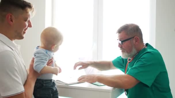 Petit enfant avec père à la réception pédiatre. Examen physique bébé portrait mignon aide bébé mode de vie sain salle ronde enfant maladie clinique test de haute qualité et concept de confiance — Video