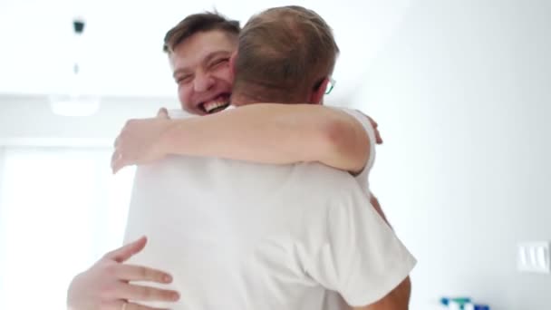 Feliz padre e hijo abrazándose cuando se reúnen en casa después de una larga separación. Padre jubilado e hijo adulto, día del padre, familia feliz — Vídeos de Stock