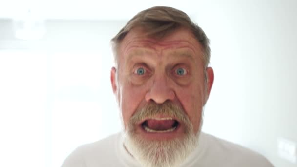 Closeup portrait senior, elderly man in glasses, looking shocked, surprised in full disbelief, wide open mouth, eyes, white background. Human emotions, facial expressions, feelings, reaction — Stock Video