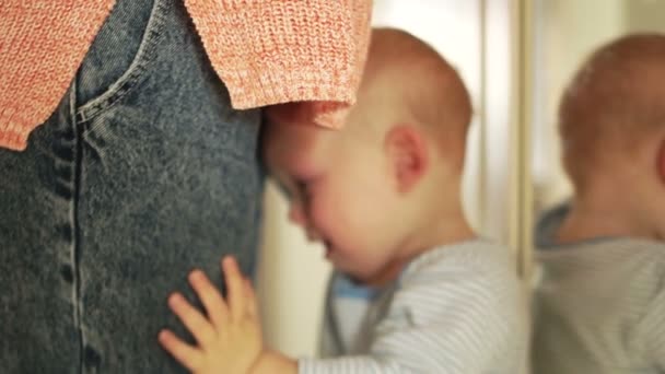 Ein weinender Junge steht neben ihrer Mutter. Kleinkind will Mamas Arme. Kinderkonzept. Schreiendes Baby, Muttertag — Stockvideo