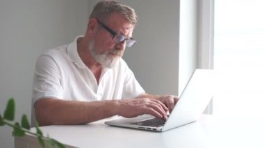 Ofiste dizüstü bilgisayarı olan bir iş adamı. Bölüm başkanı, sakallı ve gözlüklü olgun bir adam dizüstü bilgisayarla çalışıyor.