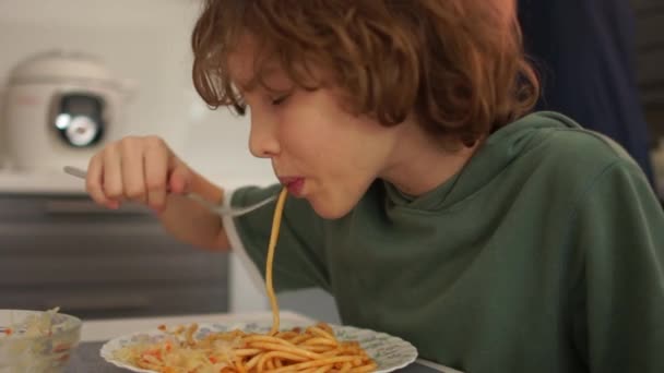 Dekat potret anak nakal remaja makan siang di rumah. Schoolboy makan pasta spaghetti Italia. Makan sehat, diet remaja — Stok Video