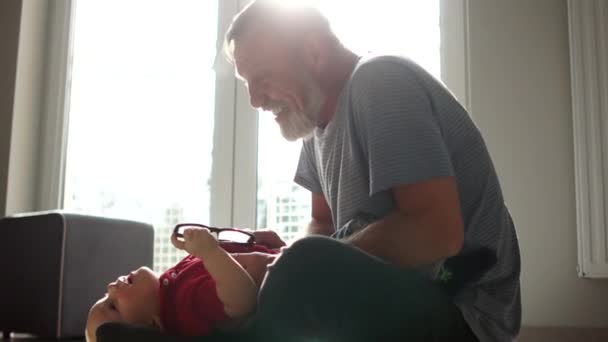 Homme baby-sitter homme avec un an et demi garçon amusez-vous dans la chambre en face de la fenêtre. Bébé heureux et sa nounou — Video