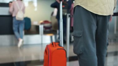 Turuncu bavullu adam uçak kalkmadan önce kayıt için sırada bekliyor. Hava Seyahati Konsepti