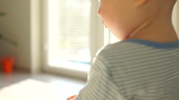 Portrait d'un beau bébé chauve d'un an et demi à la maison dans le salon. Bébé seul, enfance heureuse — Video