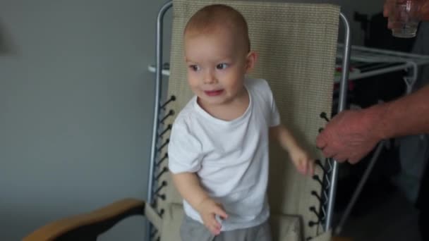 Little boy dancing standing in a chair. Adult male holds the childs hand. Child Care and Safety — 비디오