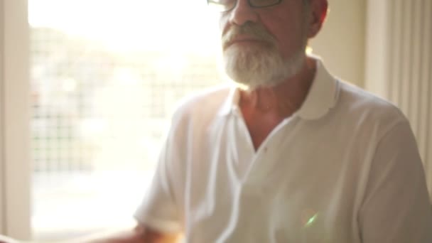 Close portrait of an elderly gray-bearded man sitting on the floor in a lotus position. Yoga classes, spiritual practices, meditation — 비디오