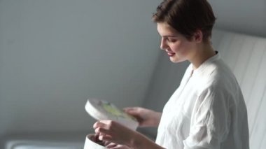 Genç bir kızın Indore portresi. Bir kadın eski bir elbiseyi bir kutudan nakışla çıkarır. Mutlu kadın.