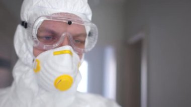 Tıbbi araştırma, koronavirüs aşısı. Koruyucu giysili, maskeli ve solunum cihazlı bir adam Coronavirus hastası için bir enjeksiyon hazırlar.