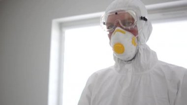 Hasta bir hastaya antiviral enjekte eden bakteriyolojik koruyucu giysiyle tanınmayan bir erkek doktor.