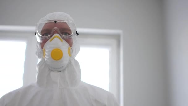 Medic in a protective suit and mask goes into an isolation chamber. Pandemic threat, coronavirus treatment, coronavirus vaccine — Stock Video