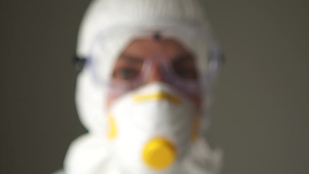 Portrait rapproché d'un homme en costume de protection. Examen médical à l'aéroport, lampe de poche pour vérifier la gorge, menace d'une pandémie de coronavirus, propagation du coronavirus — Video