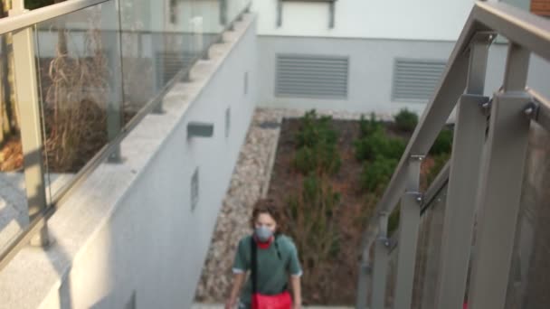 Familia de tres, un hombre enmascarado y dos hijos, un niño y una niña, van a casa en una calle de la ciudad. Régimen de emergencia, cuarentena en Europa. pandemia de coronovirus — Vídeos de Stock