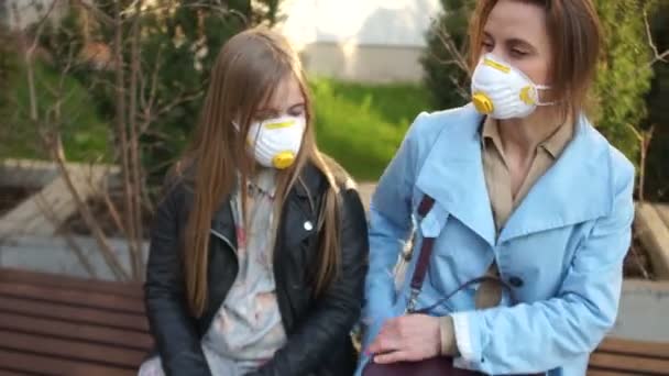 Donna e figlia indossano una maschera monouso per evitare infezioni virali. Protezione contro il coronavirus — Video Stock