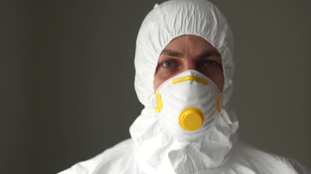 Medical staff, the threat of the spread of coronavirus, medical remedies. A close portrait of a man in a protective suit wears plastic safety glasses — Stock Video