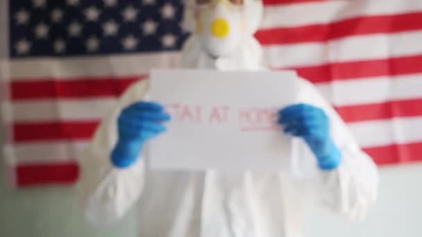 Αρσενικό γιατρό κρατώντας μια πινακίδα στα χέρια του με μια έκκληση να μείνετε στο σπίτι. επιδημία Covid-19 coronavirus στις ΗΠΑ, αυτο-απομόνωση και καραντίνα — Αρχείο Βίντεο