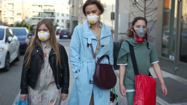 Närbild porträtt av en vacker mogen kvinna och två maskerade barn som går längs gatan. Matinköp under koronoviruspandemin. Coronavirus Covid19 — Stockvideo