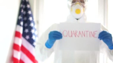 Koruyucu kıyafetli bir doktorun portresi elinde karantina yazan bir tabela tutuyor. Karantina ve kendini izole etme. Covid19 Coronavirus salgını ABD 'de