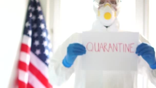 "隔離"と書かれた保護服を着た医者の肖像画だ。隔離と隔離。米国でのCovid19コロナウイルス流行 — ストック動画