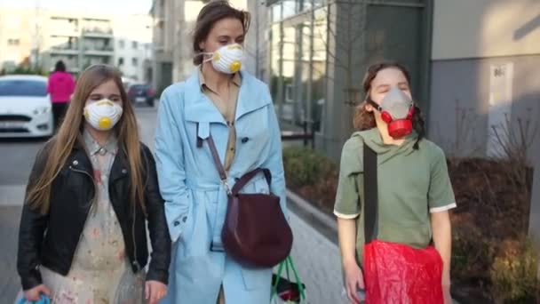 Family of three, a mother and two children, a boy and a girl, are masked on a city street. Coronovirus pandemic, emergency, quarantine in Europe, Coronavirus Covid19 — Stock Video