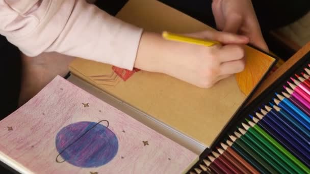 Bliski portret dzieci ręce rysować kolorowe ołówki rysunki w szkicowniku. Planeta i postać ludzka ze znakiem zapytania. Przyszłość planety — Wideo stockowe