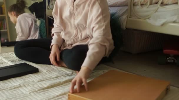 Odasındaki kız resim yapmaya hazırlanıyor. Renkli kalemlerle dolu büyük bir kutu açıyor ve çizimleriyle defterini açıyor. Karantina sanatı — Stok video