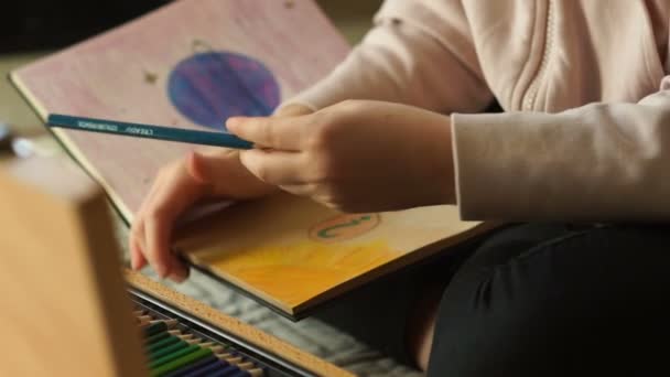 Gezegenin geleceği. Çocuk elleri çizim kutusuna renkli kalem çizimleri çizer. Soru işareti olan gezegen ve insan figürü — Stok video