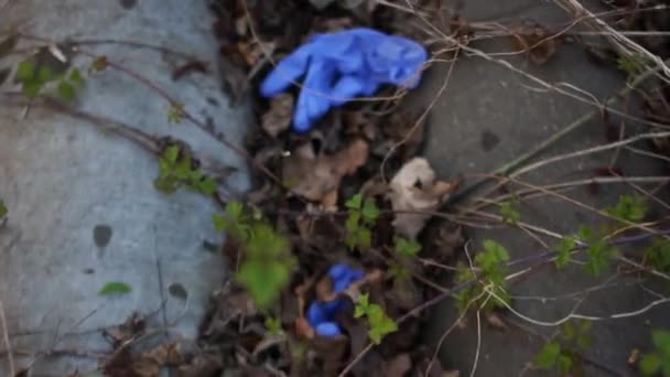 Medisch afval ligt op de grond in een park. Recycling medische maskers en handschoenen. Coronovirus Covid-19 en de ecologie van de planeet — Stockvideo