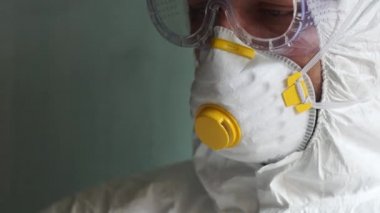 Koruyucu kıyafetli bir mikrobiyolog olan doktor kan plazma örnekleriyle test tüpleri tutuyor. Coronovirüs testi, covid-19 teşhisi