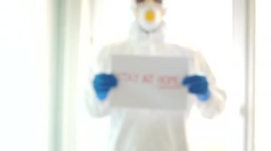 Cübbeli maske eldivenli erkek doktor. Salgın Coronavirüs 2019-ncov sarars covid-19 grip virüsü konsepti. İşaret parmağını bir kenara bırak ve evde kalmanı tavsiye et.