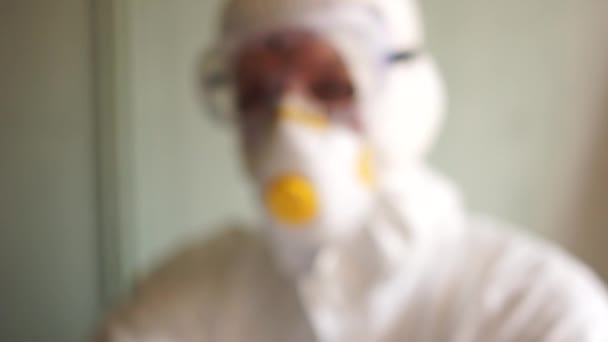 Microbiologo uomo scienziato in tuta protettiva, maschera e occhiali tiene in mano una fiala con il vaccino iscrizione. Cerca il vaccino per il coronovirus covid-19. Vaccino coronovirus — Video Stock