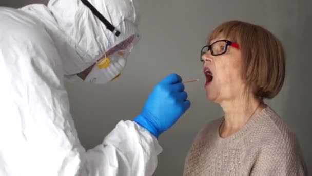 Coronavirus COVID19 buccal swab guidance. Recueillir l'ADN des cellules à l'intérieur d'une joue à l'aide d'un écouvillon effilé. Vue latérale d'une femme âgée — Video