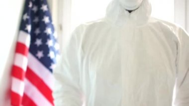 Karantina ve kendini izole etme. ABD 'de Covid19 Coronavirüs salgını. Koruyucu takım elbiseli bir adamın elinde Covid19 yazan bir tabela olan portresi.