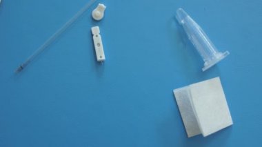 Hızlı test covid 19. Doktorlar koruyucu bir eldiven verip masaya SARS-CoV-2 ile sonuçlanan bir test kaseti koyuyorlar.
