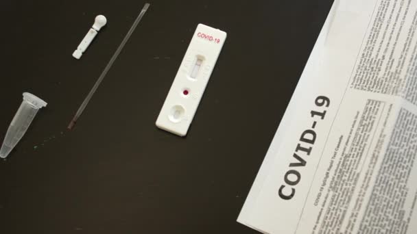 Detailní záběr použitého testovacího systému pro stanovení kovidu koronaviru-19 invazivní metodou. Testovací kazeta vykazuje negativní výsledek — Stock video