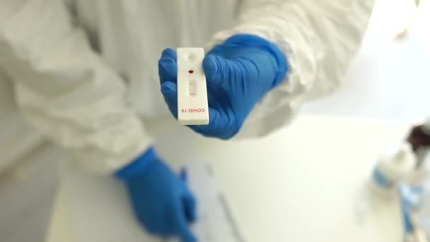 Laboratorní kazeta testovala NEGATIVE na virus viru koronaviru SARS-CoV-2. Rychlý test covid19. Doctor holding a test kit for vial disease COVID-19 2019-nCoV — Stock video