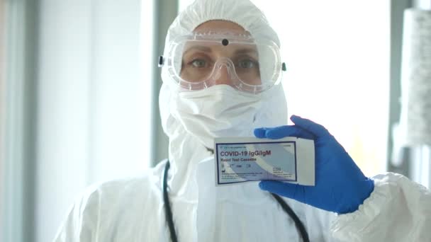 Wroclaw Polen - 23 april 2020. Expresstest vid 19. Porträtt av en läkare kvinna i skyddsdräkt whis testkassett för att upptäcka covid-19 SARS-CoV-2 virus med PCR diagnostisk metod — Stockvideo